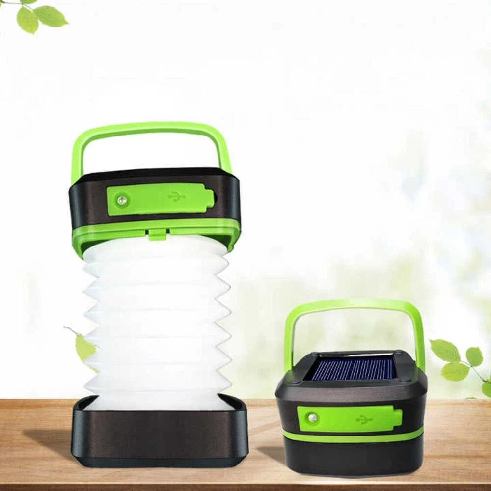 Two solar-powered lanterns with green handles on a wooden surface.