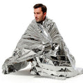 Person wrapped in a silver mylar blanket on a white background