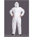A person wearing a white disposable protective coverall suit with a hood and face mask, standing against a dark gray studio background.