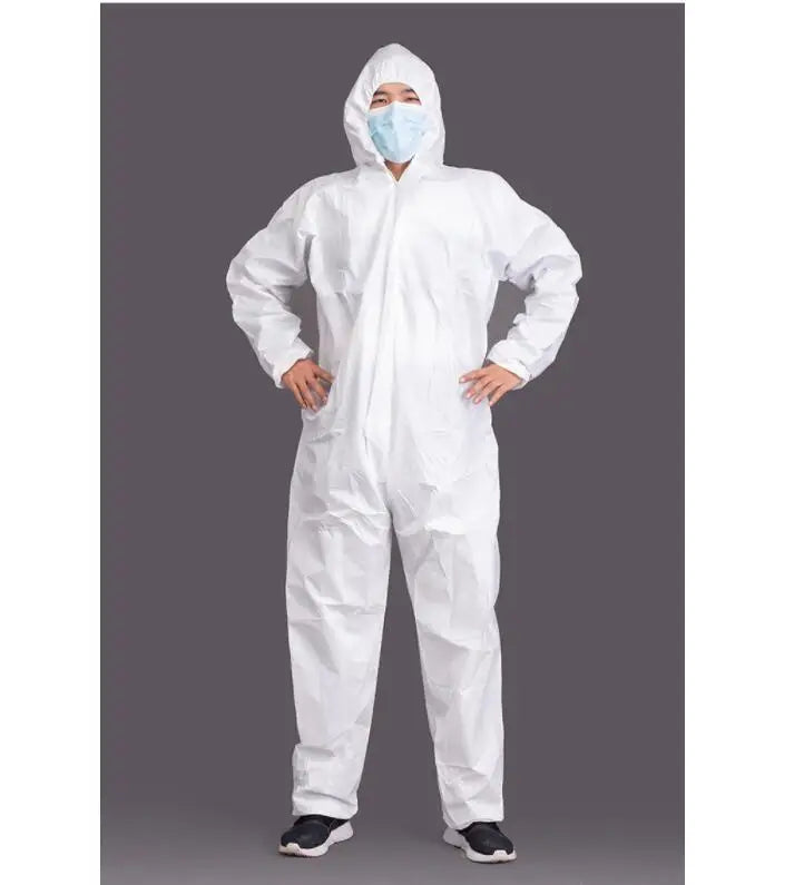 A person wearing a white disposable protective coverall suit with a hood and face mask, standing against a dark gray studio background.