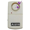 An off-white plastic vibration alarm device with a circular dial on top, a small red indicator light, and a black label reading 'VIBRATION Alarm'. A purple lightning bolt graphic is overlaid near the top right.