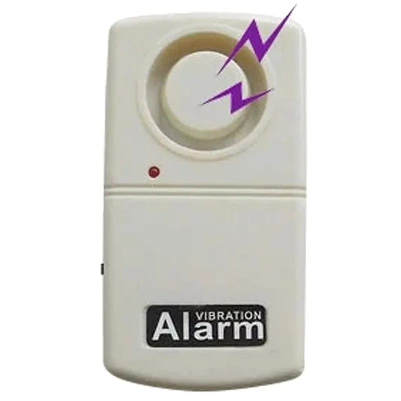 An off-white plastic vibration alarm device with a circular dial on top, a small red indicator light, and a black label reading 'VIBRATION Alarm'. A purple lightning bolt graphic is overlaid near the top right.