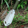 Multitool knife with a green handle in grass