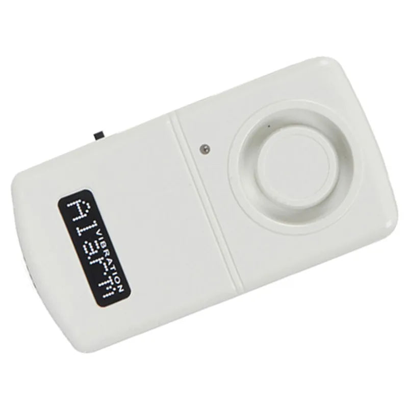 A white plastic vibration alarm sensor with a digital LED display showing 'ALARM' and 'VIBRATION DETECTOR'.
