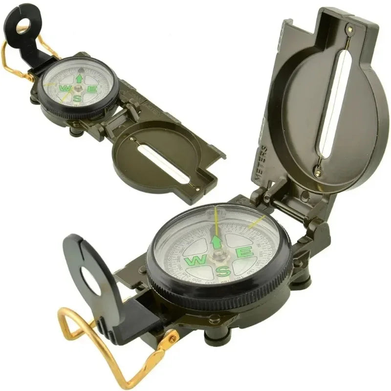 A military-style compass with a hinged cover, shown open and closed on a plain white background. The compass has a dark olive green body, a clear lens, a white dial face with green lettering, and brass/gold-toned hardware.