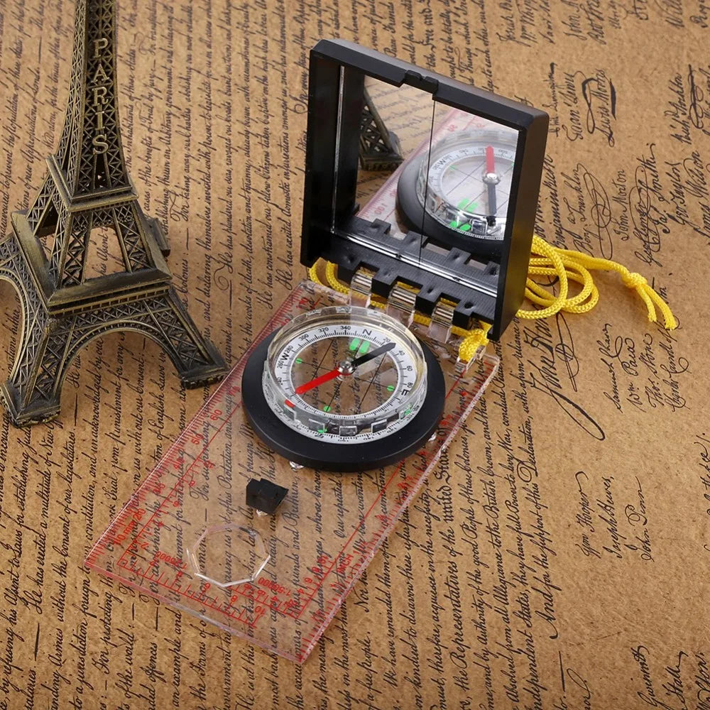 Compass with a clear cover on a textured surface resembling old paper with writing