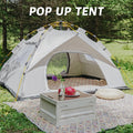 Pop-up tent set up outdoors with a table and decorative items.