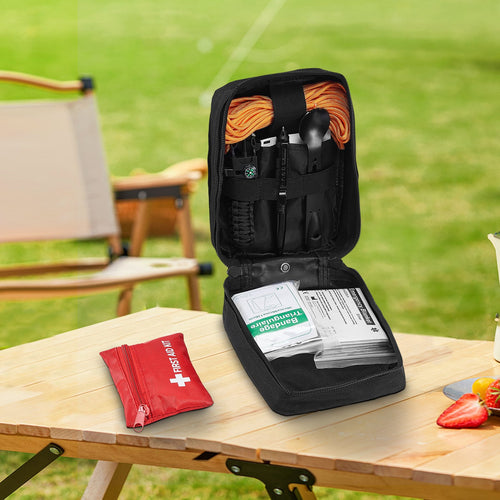 First aid kit and tools in a black case on a wooden table outdoors.