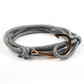 Bracelet with rope design and rose gold anchor clasp on a white background